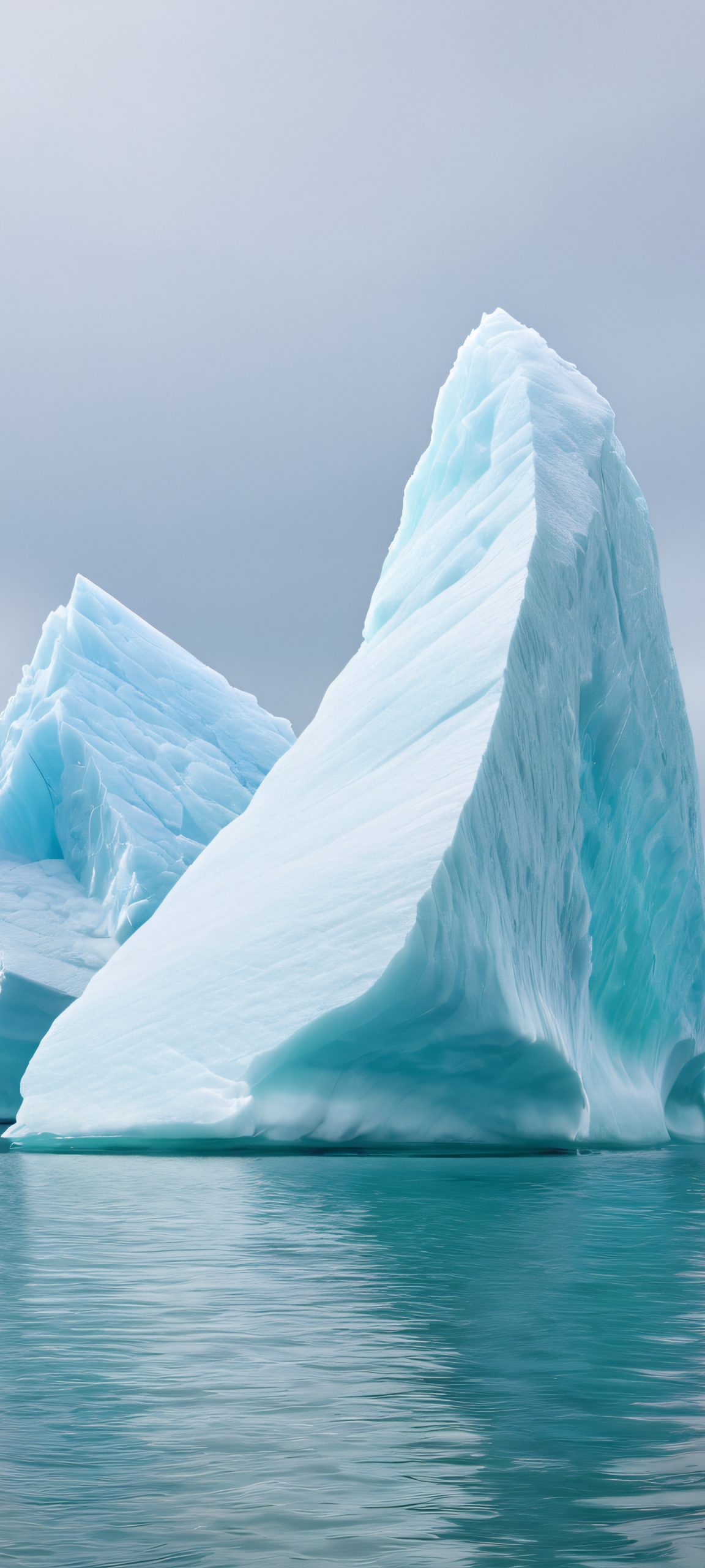 Stunning vertical wallpaper of an iceberg at seaside, featuring soft overcast, bluish grey, icy white, and muted greens. Perfectly optimized for iPhone, Samsung Galaxy, and Android home screens.