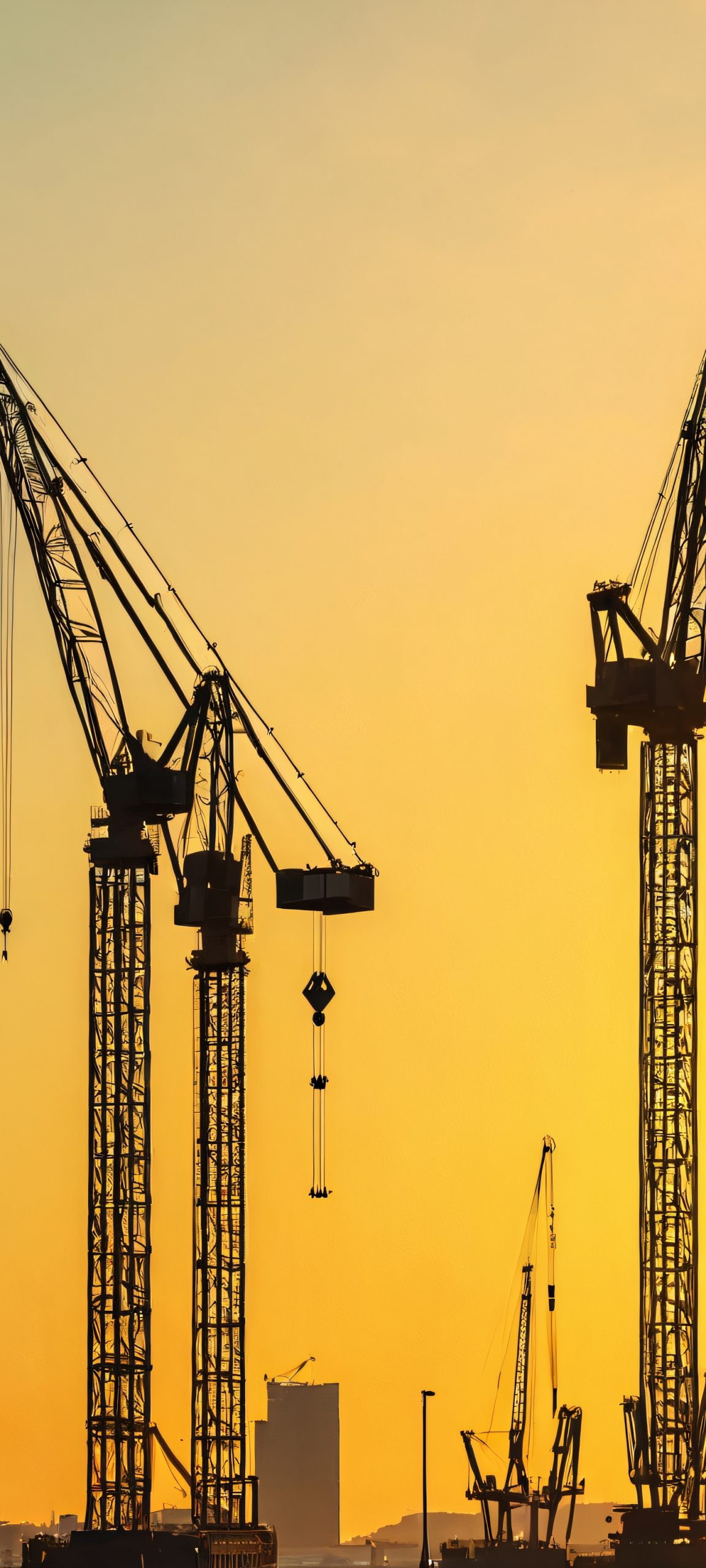A stunning iPhone and Android compatible wallpaper featuring Harbor Cranes against a vibrant cityscape during the golden hour, with a mix of blues, greens, and yellows.