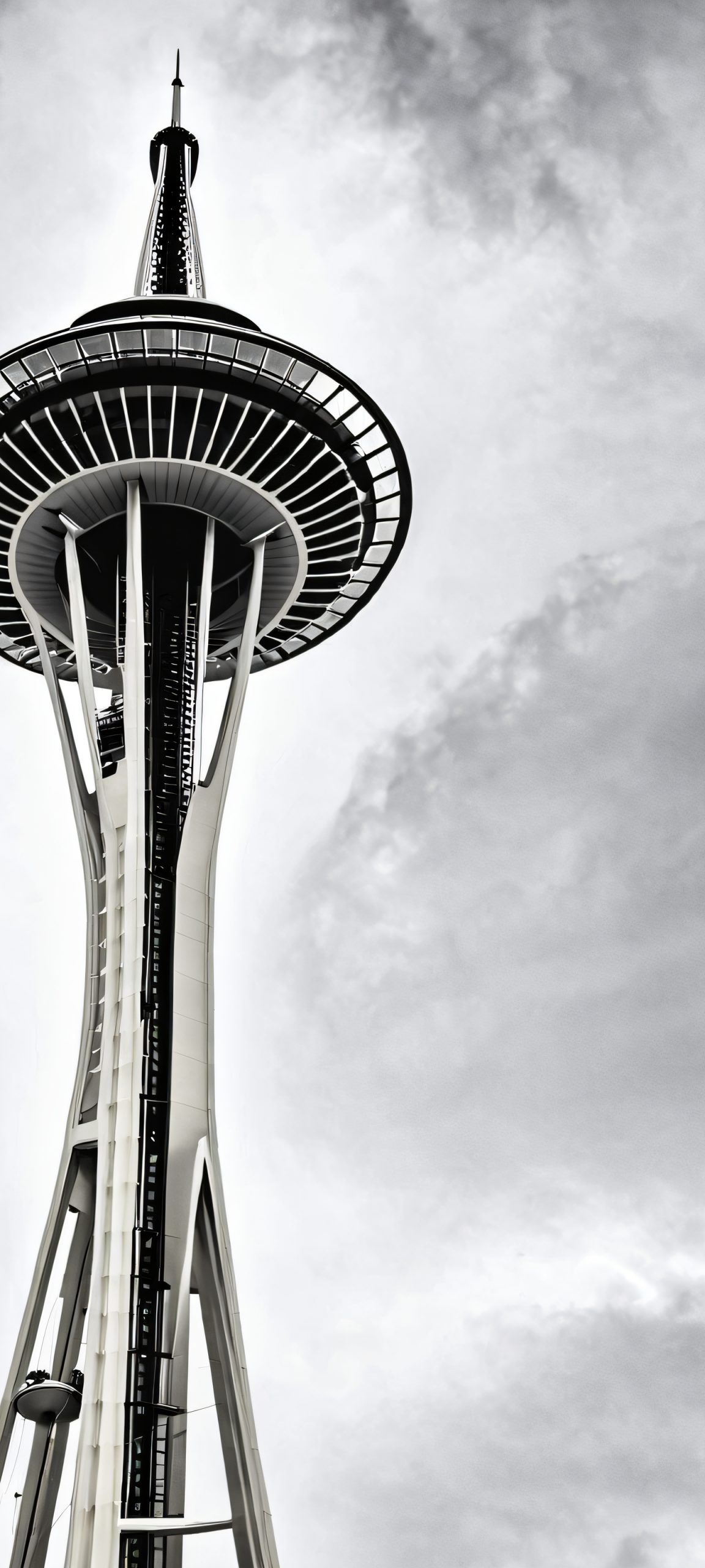 iPhone and Android users can download this stunning vertical Space Needle wallpaper featuring a cloudy sunset with soft white and grey hues.