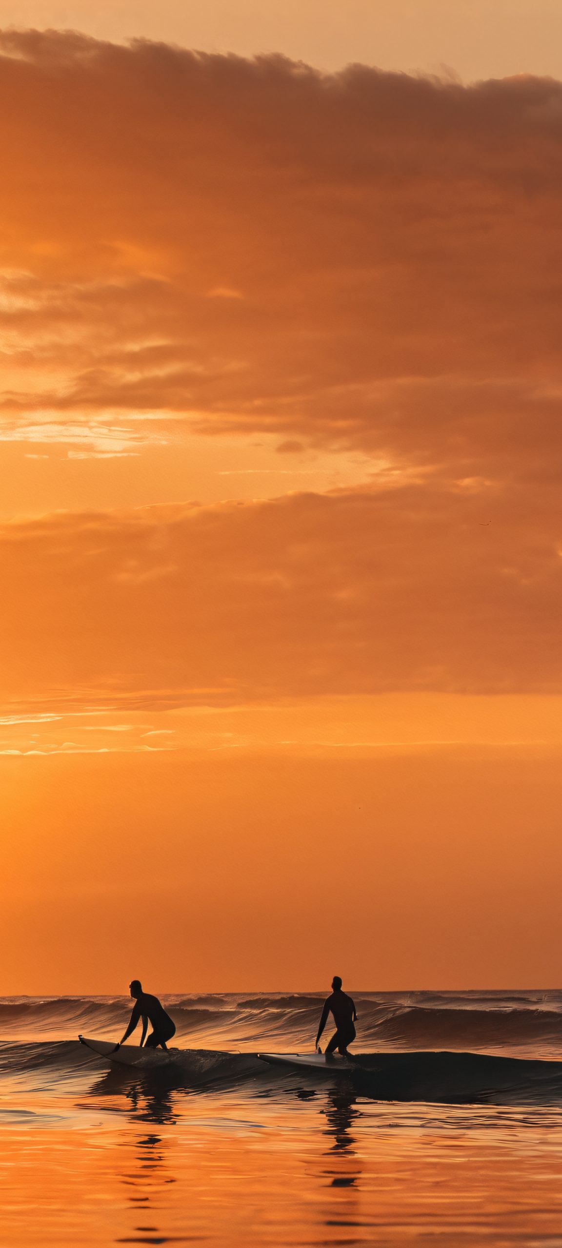 Surfers enjoying the sunset on a cloudy day - perfect for iPhone and Android home screens